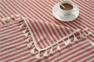Close-up of red and white striped cotton tablecloth featuring delicate white fringe edges