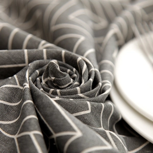 Macro detail of dark grey linen tablecloth with white geometric grid patterns and texture