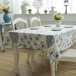 Close-up of thick cotton canvas tablecloth with navy blue leaves and red ladybug patterns