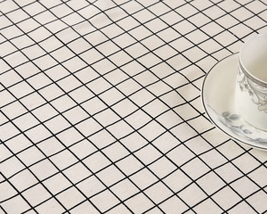 Detailansicht der schwarz-weiß karierten Tischdecke aus Baumwoll-Polyester mit Keramik-Teeservice