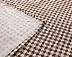 Macro shot of striped cotton fabric edge with fine stitching and woven texture detail
