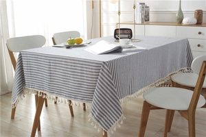 Detail of blue and white striped cotton tablecloth with white decorative tassels