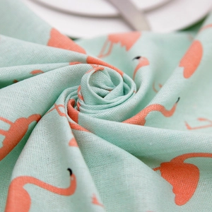 Detail of mint green flamingo print tablecloth showing textured cotton linen fabric weave