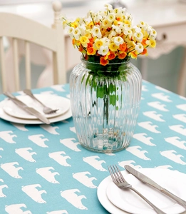 Detail of light blue tablecloth with white polar bear print and Nordic floral setting
