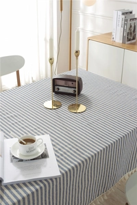 Close-up of blue and white striped cotton-linen tablecloth with beige fringe edges