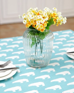 Detail showing cartoon white polar bear print on light blue tablecloth with dining set