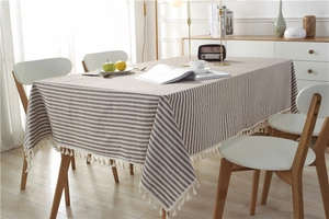 Close-up of striped cotton linen tablecloth with delicate white tassel fringe detail