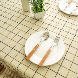 Macro detail of geometric checkered tablecloth with elegant cream tassel fringe decor