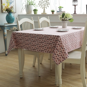 Modern cotton floral tablecloth with pink daisy pattern on a white dining table