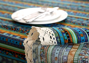 Detail of bohemian cotton linen tablecloth with ethnic patterns and lace edges