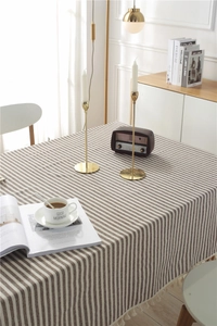 Close-up of brown and beige striped tablecloth with elegant tassel trim and cotton texture