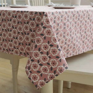 Detailed close-up of pink floral cotton canvas tablecloth on a modern white dining table