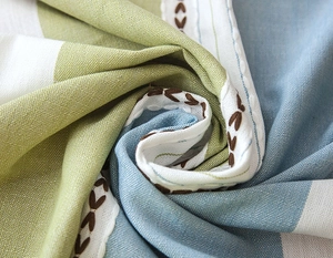 Close-up of jacquard striped tablecloth with refined embroidery and fringe detail
