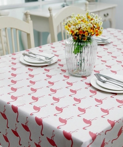 Detail of flamingo print tablecloth showing the thick cotton linen fabric texture on a table