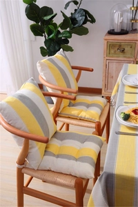 Detail showing high-quality yellow and gray striped chair cushions with white ties