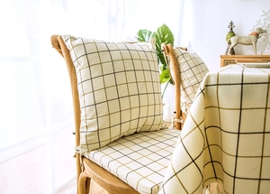 Close-up of beige waterproof tablecloth with yellow and black geometric checkered pattern