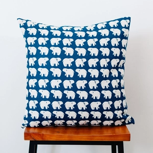 Detail of Nordic throw pillow with white polar bear print on navy textured cotton fabric