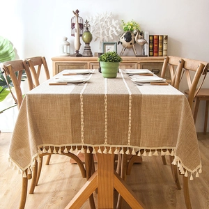 Close-up of jacquard striped tablecloth with delicate beige fringe tassels on edges