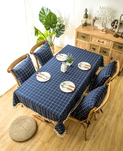Detail of dark blue plaid tablecloth and matching cushioned chair pads with elegant tassels