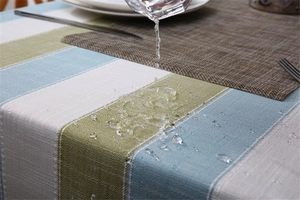 Close-up of waterproof striped linen tablecloth showing water droplets beading on surface