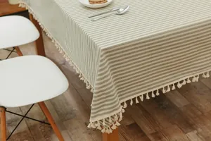 Close-up of green and white striped tablecloth featuring elegant tassel fringe edges