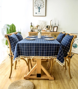 Detail of navy blue plaid tablecloth with white fringe and matching chair cushions