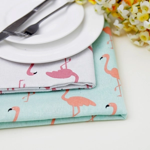 Linen flamingo print tablecloth with elegant tableware for a fresh dining scene