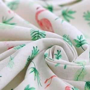 Linen-style tablecloth featuring pink flamingo and green tropical leaf prints