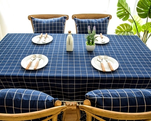 Detail of navy blue plaid tablecloth featuring elegant fringe and woven jacquard texture