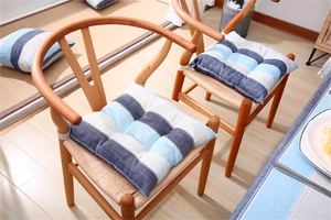 Detail of blue striped linen chair cushion with tufted texture and secure ties