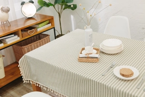 Detailed view of the olive green striped cotton linen tablecloth with fringe edges
