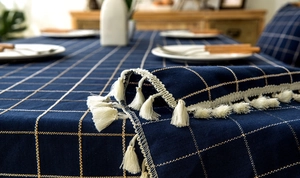 Close-up of navy blue plaid tablecloth featuring detailed white fringe edges and woven texture