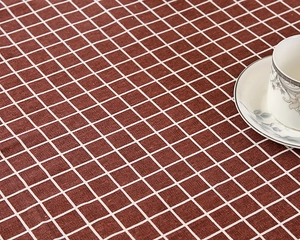 Nahaufnahme der rot-weißen Tischdecke mit rustikaler Textur und einer Keramiktasse