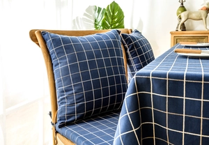 Detail of blue plaid jacquard tablecloth with rustic tassels and matching chair cushions
