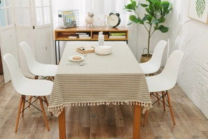 Close-up of minimalist striped table cloth with white decorative tassel fringe details