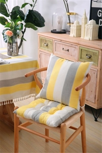 Close-up of yellow and grey striped cushion and quilted seat pad on a chair