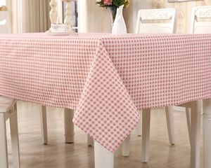 Detail of red and white checkered tablecloth with a soft drape on a white dining table