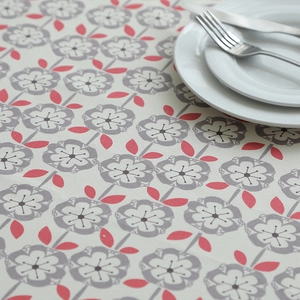 Close-up of thick cotton canvas tablecloth with grey floral and red leaf patterns