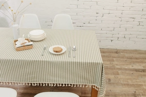 Detailed view of green striped polyester-cotton tablecloth with cream fringe edge