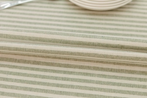 Detailed macro view of green and white striped cotton-linen fabric with fringe