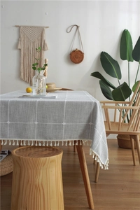 Close-up of gray plaid tablecloth with Nordic embroidery and elegant fringe tassels