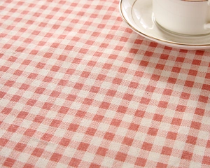 Close-up of red and white checkered tablecloth with high-density weave and neat stitching