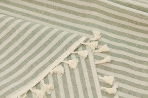 Detail of green and white striped cotton-linen fabric with fringe edges for tablecloth
