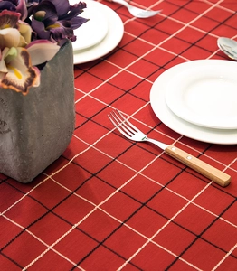 Close-up of red plaid waterproof tablecloth with fringe edge and elegant dining setup