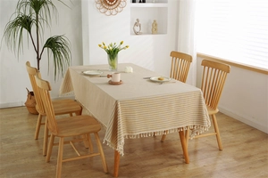 Detailed view of yellow and white striped cotton-linen tablecloth with tassel fringe