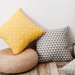 Nordic style plaid and geometric square decorative pillows on a wooden floor