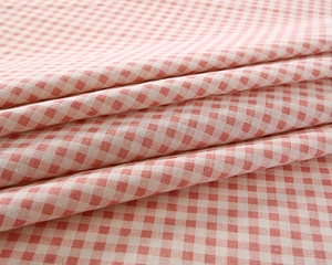 Close-up of soft red and white gingham fabric with detailed cotton weave texture