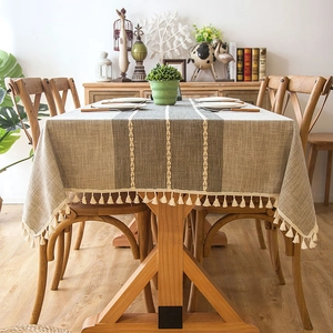 Close-up of geometric striped jacquard tablecloth with elegant beige tassel fringe edges