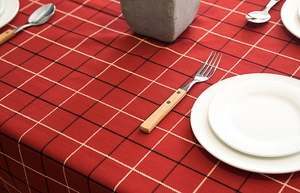 Detailed view of red plaid tablecloth with jacquard weave and vintage fringe edges