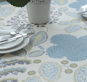 Close-up of thick cotton canvas tablecloth with blue and green leaf patterns in a cozy setting